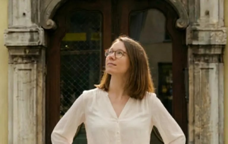 Woman posing in front of a historic stone doorway during a Graz photography tour.