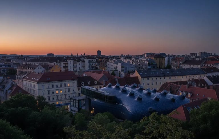 Aerial twilight view of Graz Austria with Kunsthaus roof glowing at sunset