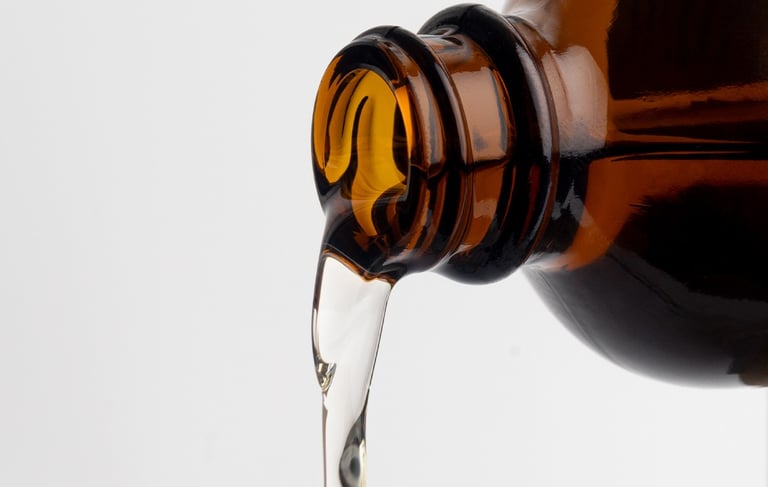a brown bottle with clear liquid pouring out