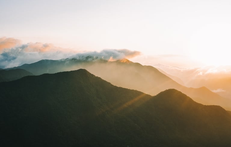 a mountain scene with the sun rising