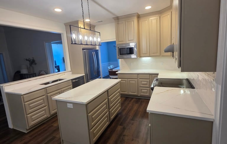 Modern kitchen featuring beige cabinets, quartz countertops, a central island, and dark wood flooring.