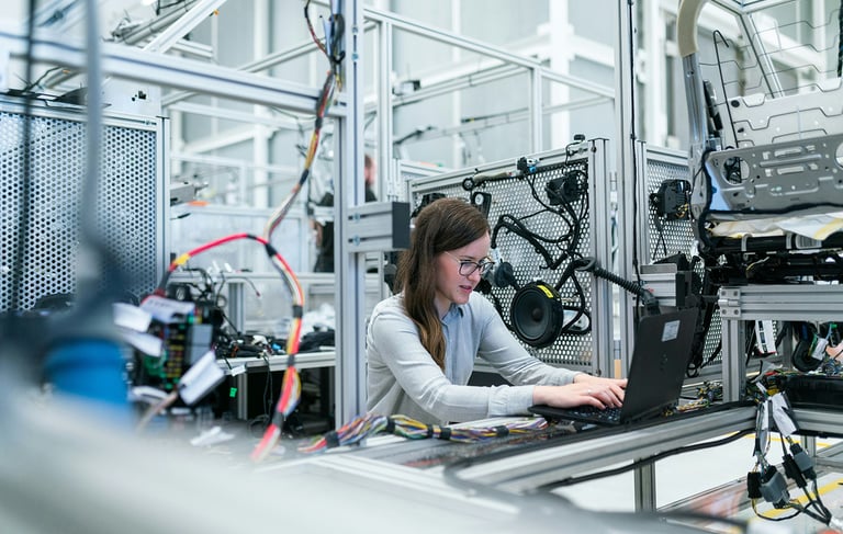 a woman in a lab coat is working on a laptop
