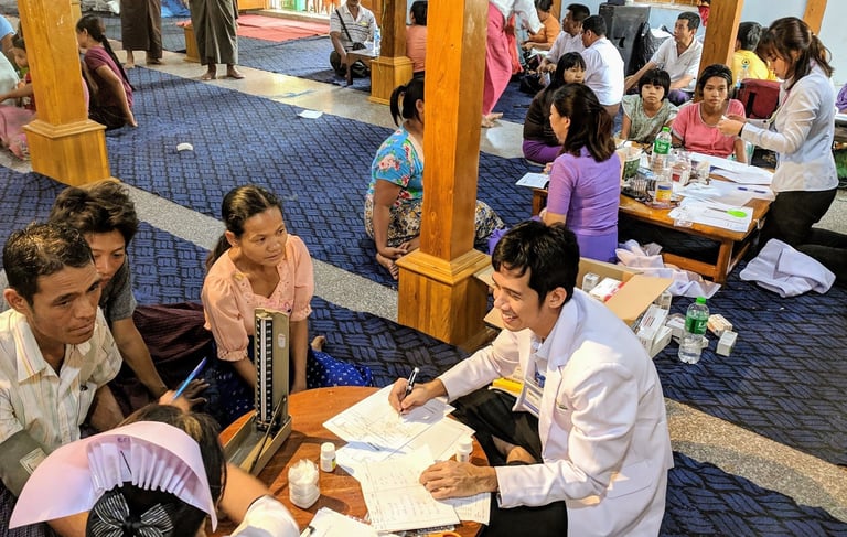 Dr Zaw wearing a smile seeing patients and family members sitting in front of him