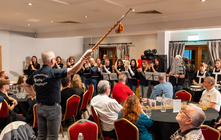Indoor celebration with seated guests and live wind instrument performance