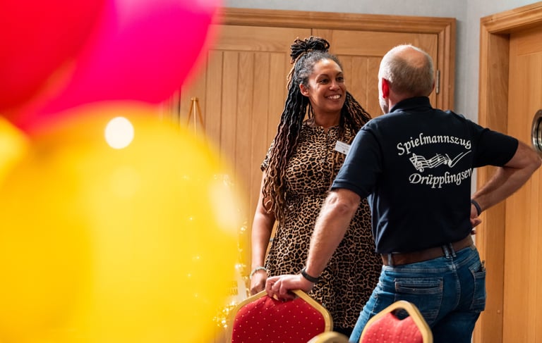 Two people chatting at a community event - a candid moment of connection in a vibrant setting