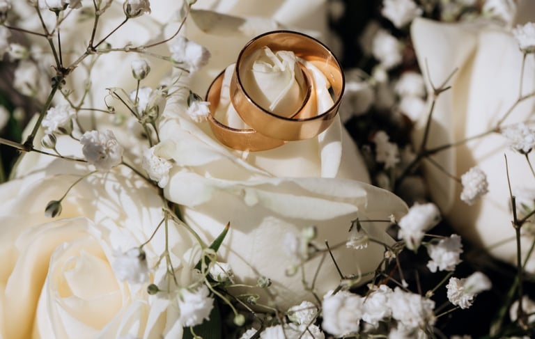 a couple of wedding rings on a bouquet of flowers