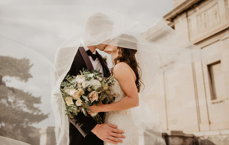 a bride and groom standing in front of a building