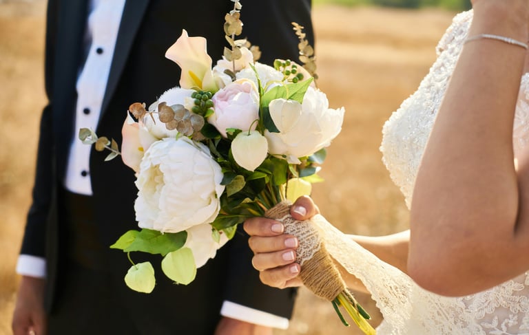 a bride and groom are holding a bouquet