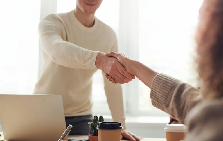 a man and woman shaking hands in a meeting