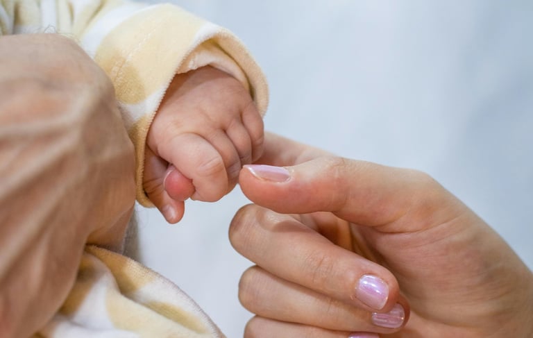 a baby's hand holding a baby's finger