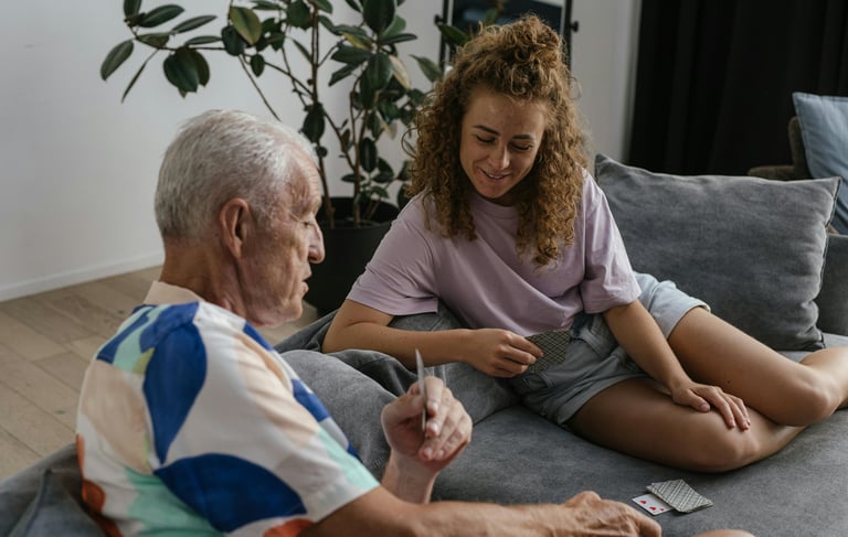 a woman sitting on a couch with a man holding a remote control
