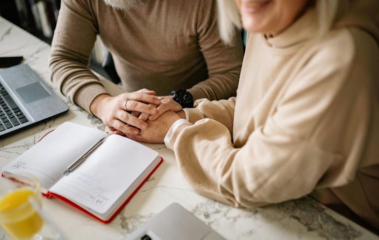 a man and woman holding hands over a notebook