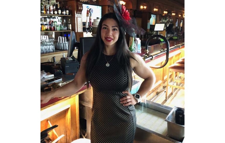 a woman in a dress and hat standing in front of a bar, TWC Financial client