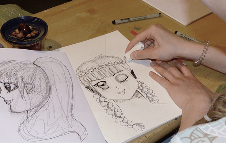 Schülerin zeichnet eine Comicfigur