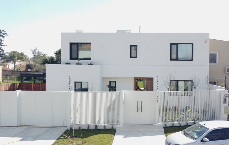 Una casa blanca con un área cercada de color blanco.
