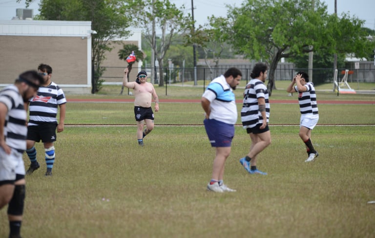 a group of men playing a game of rugby shirtless