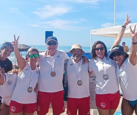 a group of people standing around a beach