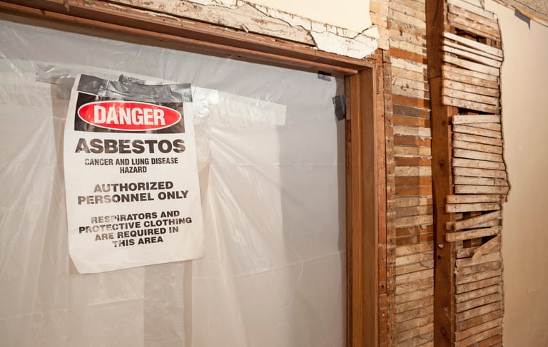 a sign warning of asbestos on a brick wall