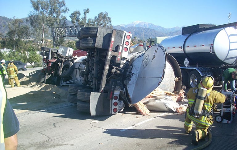 a firefighter standing next to a truck with a hose attached to it