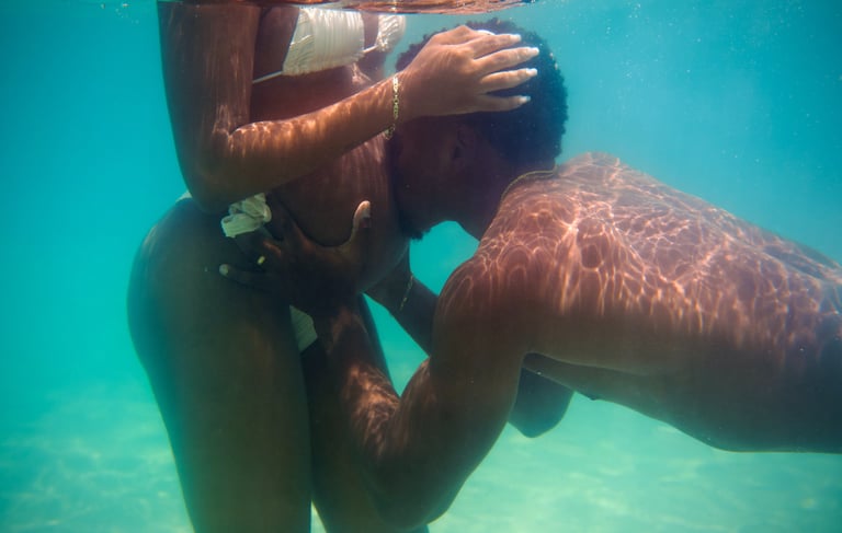 un homme embrasse sa femme enceinte sous l'eau