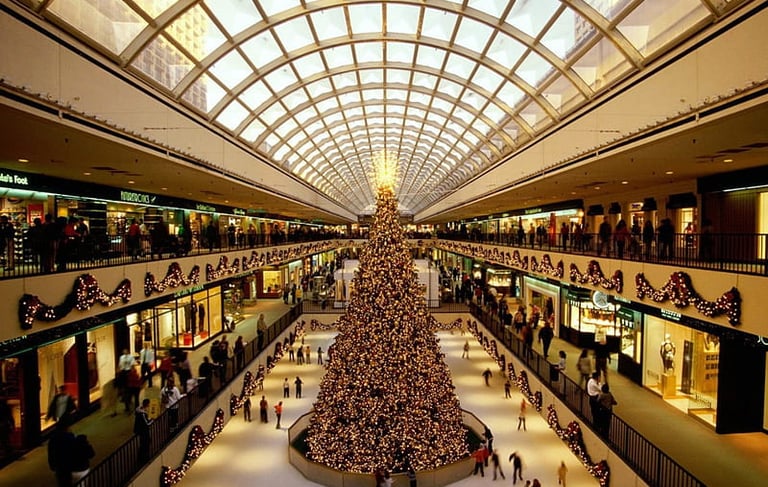 a large christmas tree in a mall with people walking around