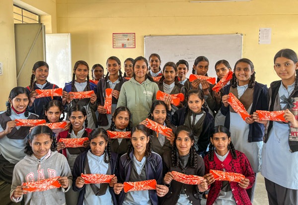 Class of schoolgirls holding up a Hanaru reusable sanitary napkin