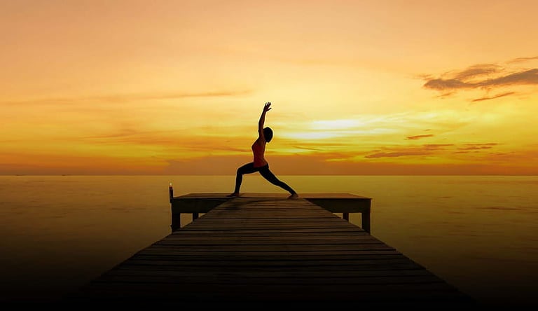 Stock photo of yoga students moving through a Vinyasa flow sequence