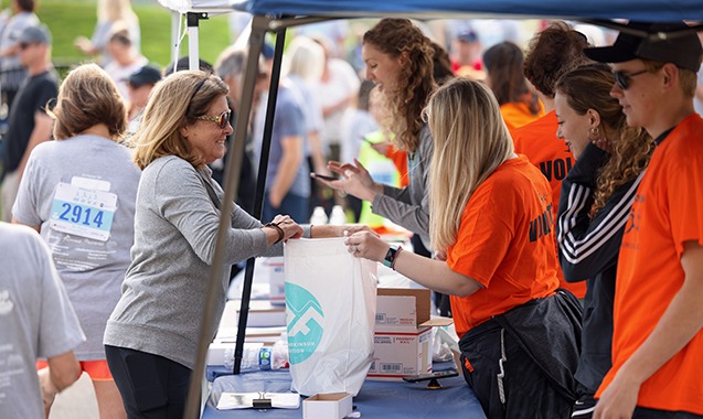 a photo of a runner completing their packet pickup before a race