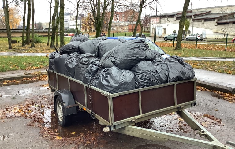 Lapai, spygliai ir kitos atliekos sukrautos maišuose, vežamos utilizuoti