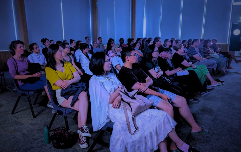 Diverse audience enjoying a cozy film screening at Auckland International Film Club.