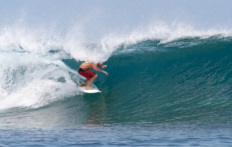 Surfer carving inside crystal clear barrel at Telescopes, Mentawai