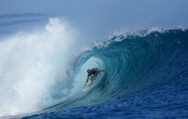 Surfer deep inside turquoise barrel at secret Mentawai surf spot