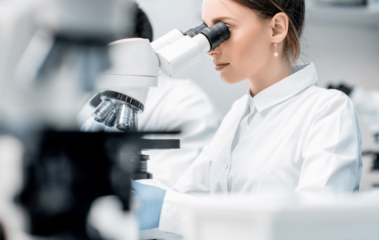 Naukowiec analizujący próbki pod mikroskopem w laboratorium badawczym.