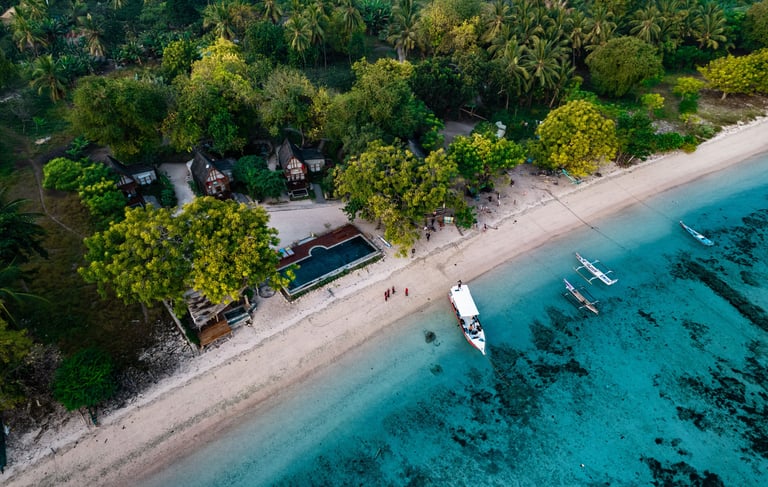 a dive boat is parked on the shore of a beach next to a resort