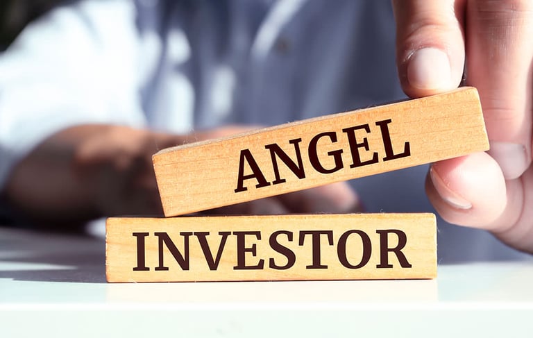 a person holding a wooden block with the words angel investor