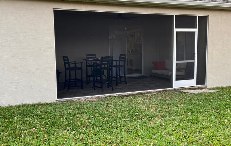 a patio with a table and chairs in the grass