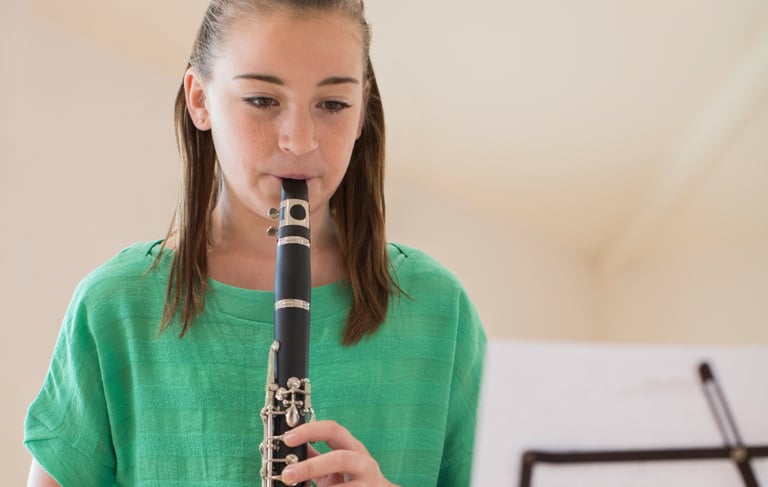 a girl in a green shirt playing a flute
