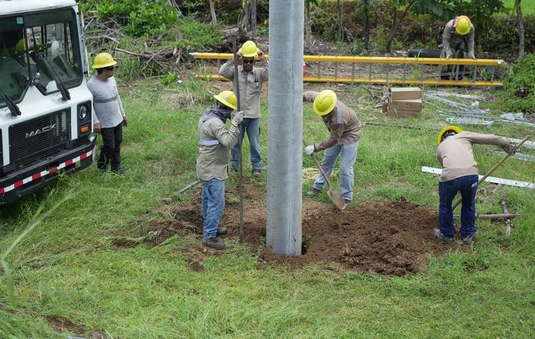 grupo de hombres haciendo un hoyo para instalacion de poste electrico