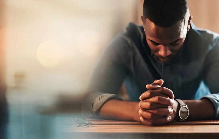 un homme assis à une table avec un ordinateur portable et un téléphone portable
