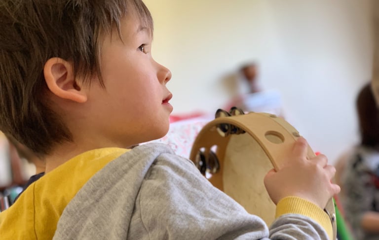 Young child holding a tambourine