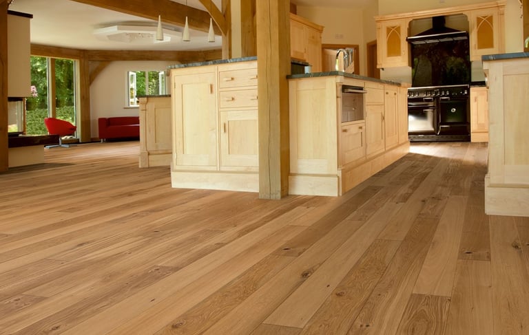 Wide plank hardwood floors in kitchen and living area, natural wood tones.