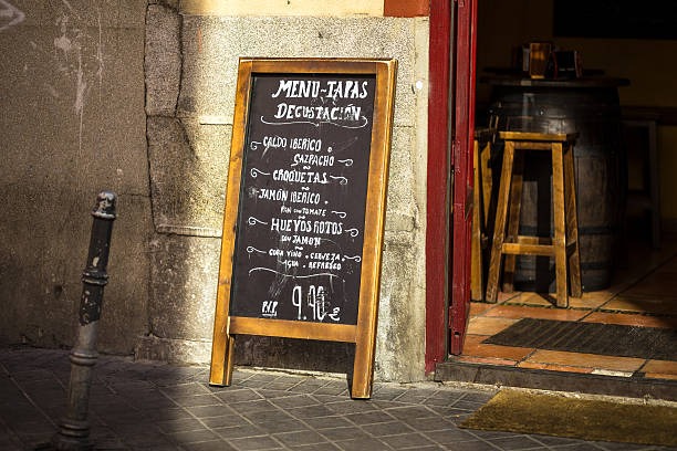 Una valla publicitaria apoyada en la entrada de un restaurante.
