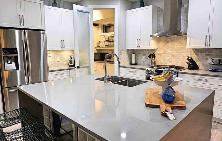 High gloss countertop and white kitchen cabinets euro-style in a kitchen in lake country