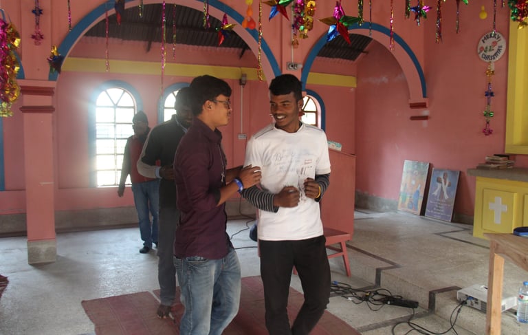 two men standing in a room with a pink wall