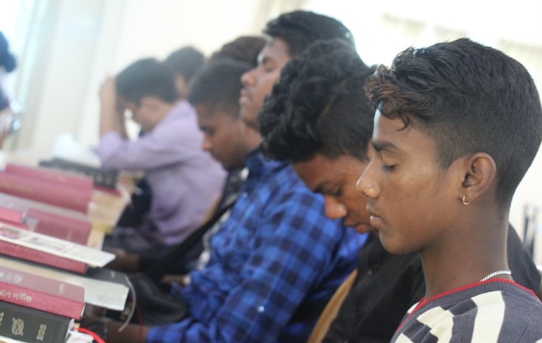 a group of people sitting at a table with books
