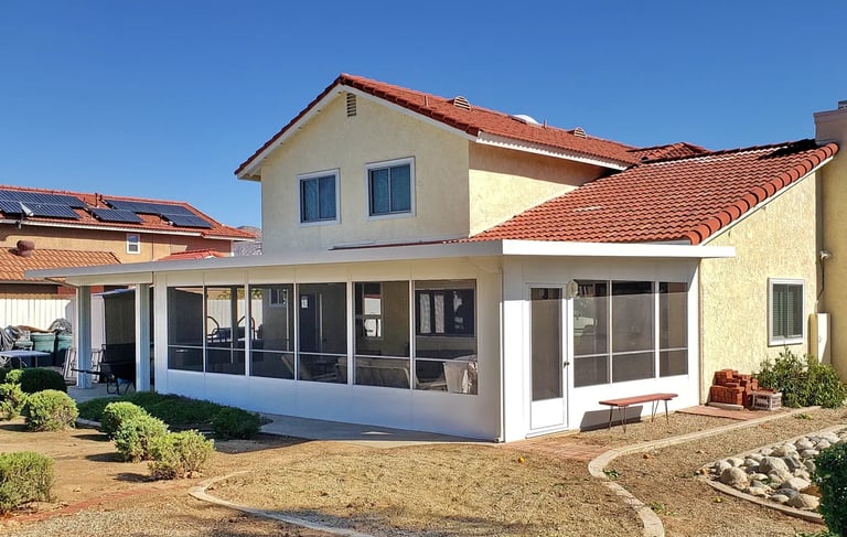 Two story yellow home with large white screened in patio.