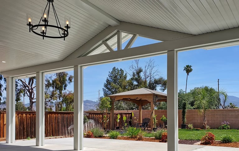 Alumawood patio cover with gabled center section and hanging light fixture. Color is white.