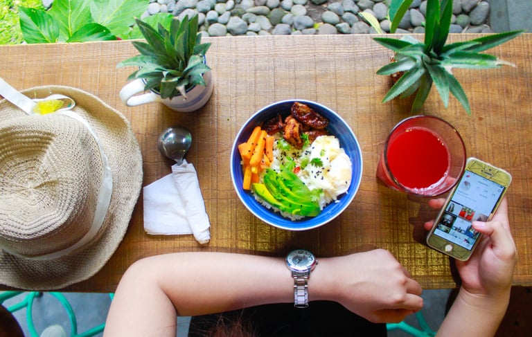 woman holding iphone while eating