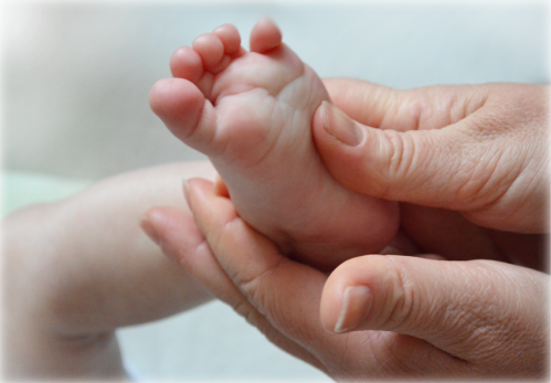mains massant un pied de bébé