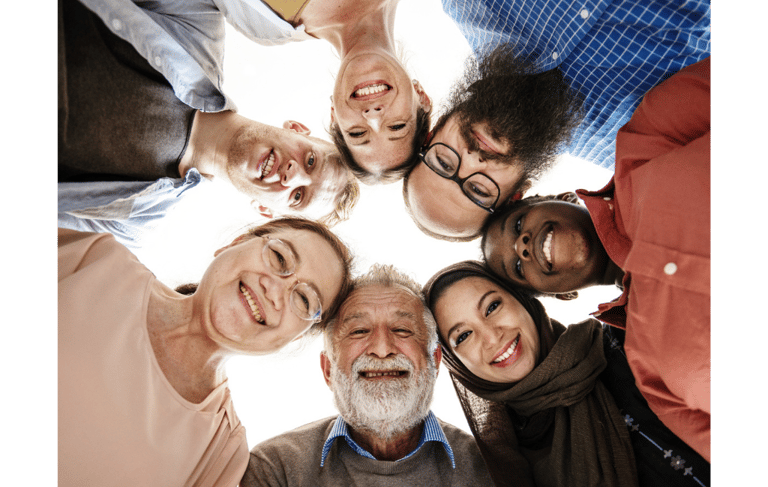 Lächelnde Menschen im Kreis stehen für Teamwork und Vielfalt – Systemisches Coaching, Workshops und 